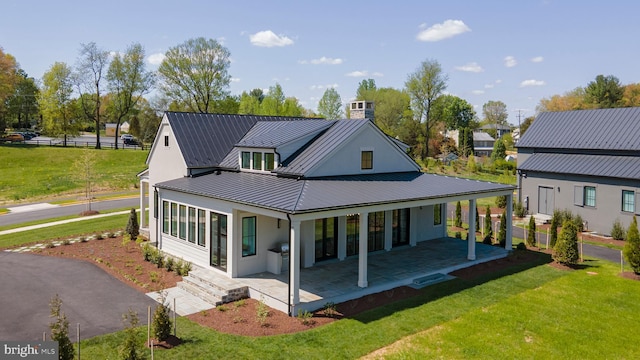 rear view of house with a yard and a patio area