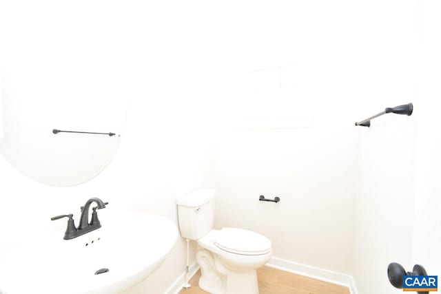 bathroom with hardwood / wood-style flooring, toilet, and sink