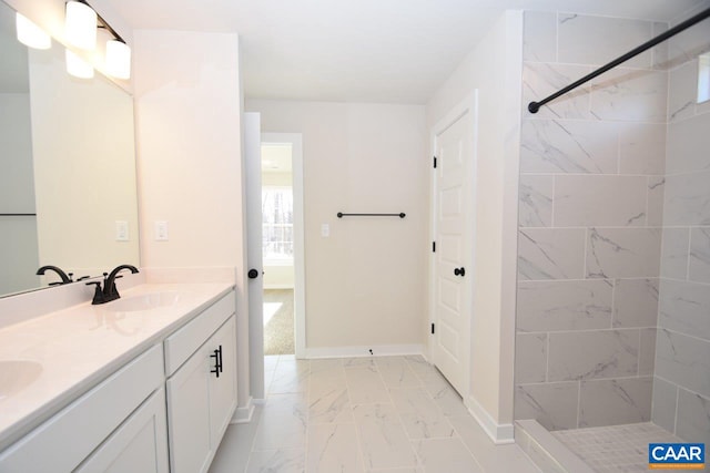 bathroom featuring a tile shower and vanity