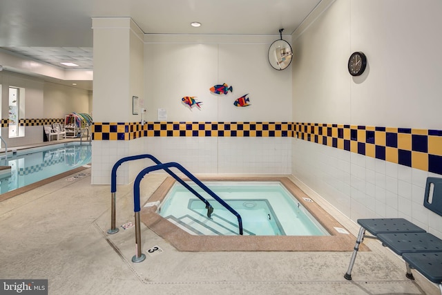 view of swimming pool featuring an indoor hot tub