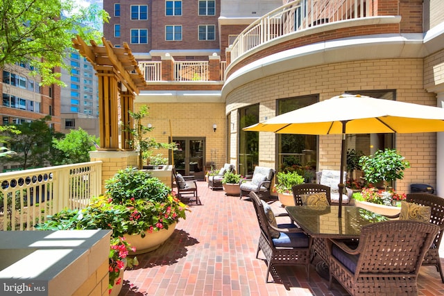 view of terrace featuring a pergola and a balcony