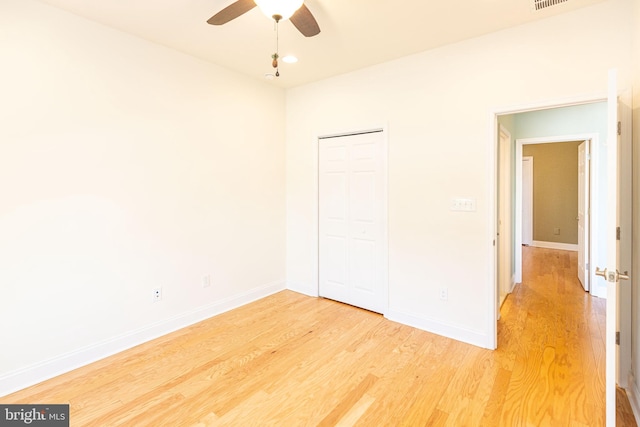 unfurnished bedroom with ceiling fan, a closet, and hardwood / wood-style floors