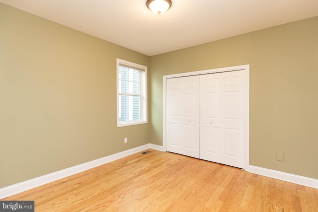 unfurnished bedroom with light hardwood / wood-style floors and a closet