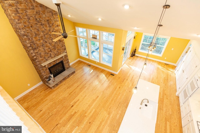 living room with ceiling fan, light hardwood / wood-style floors, and a fireplace