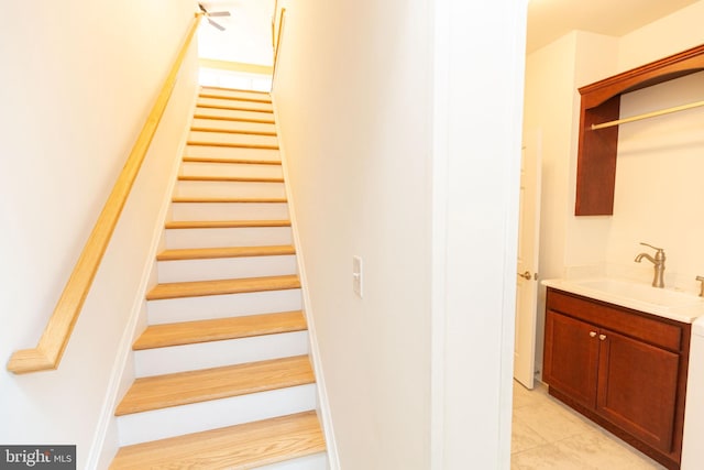 staircase featuring tile patterned flooring and sink