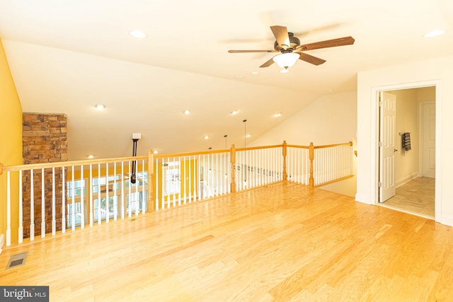 unfurnished room with hardwood / wood-style flooring, ceiling fan, and vaulted ceiling