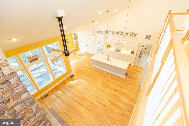 interior space featuring ceiling fan, hardwood / wood-style floors, and high vaulted ceiling