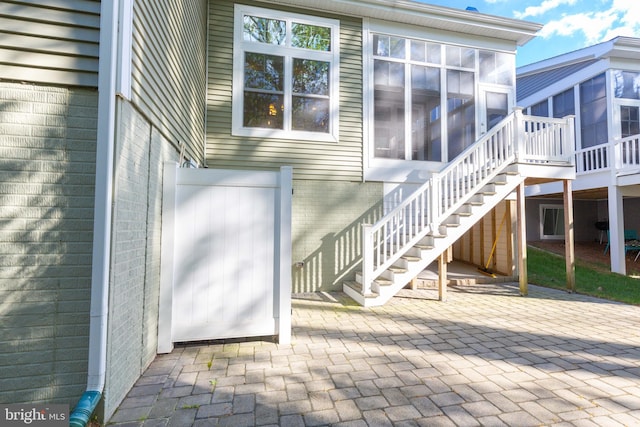 view of exterior entry with a patio area and elevator