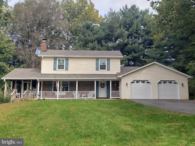 view of front of house with a front yard, a garage, and covered porch