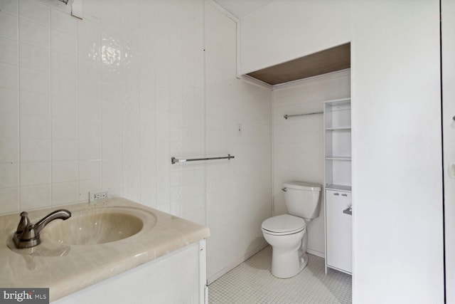 bathroom featuring tile walls, tile floors, vanity, and toilet