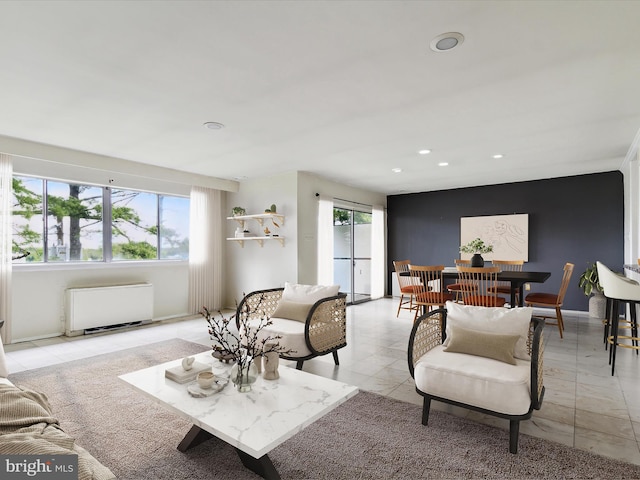 living room featuring light tile floors and radiator heating unit