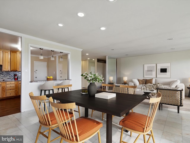 dining area with crown molding and light tile flooring