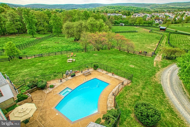 view of pool featuring a rural view, a yard, and a patio area