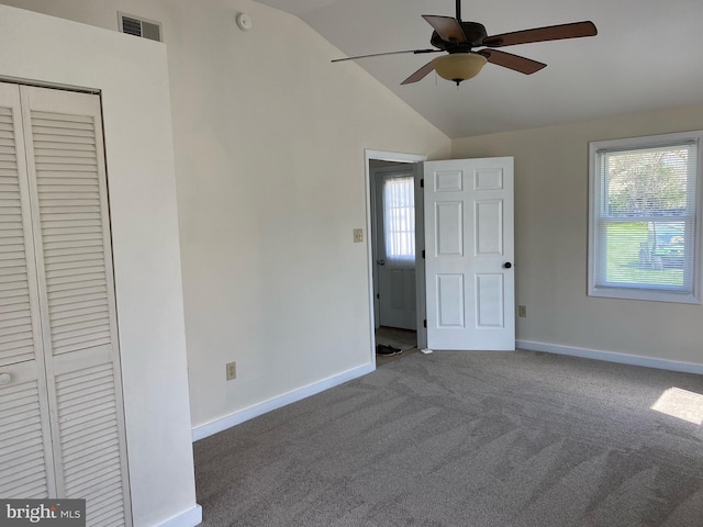 carpeted empty room featuring ceiling fan and vaulted ceiling