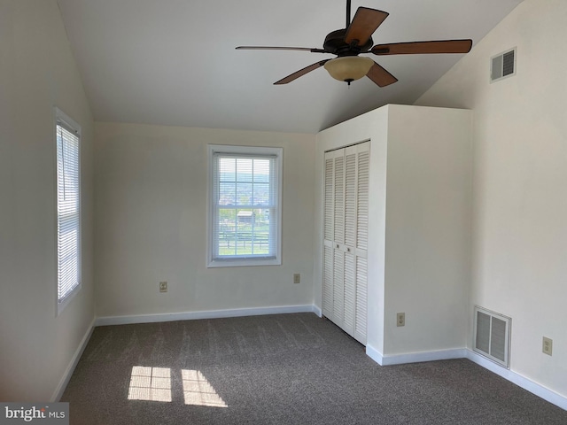 carpeted empty room featuring ceiling fan and vaulted ceiling