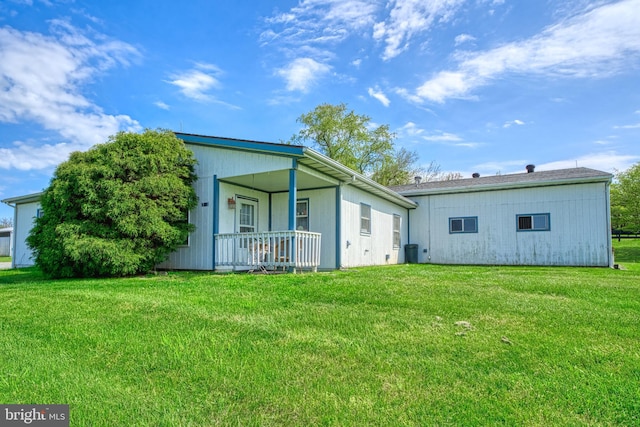 rear view of house with covered porch and a lawn