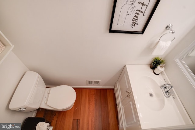 bathroom with vanity, hardwood / wood-style flooring, and toilet