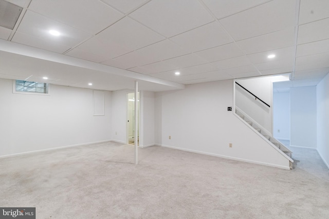 basement with light carpet and a drop ceiling