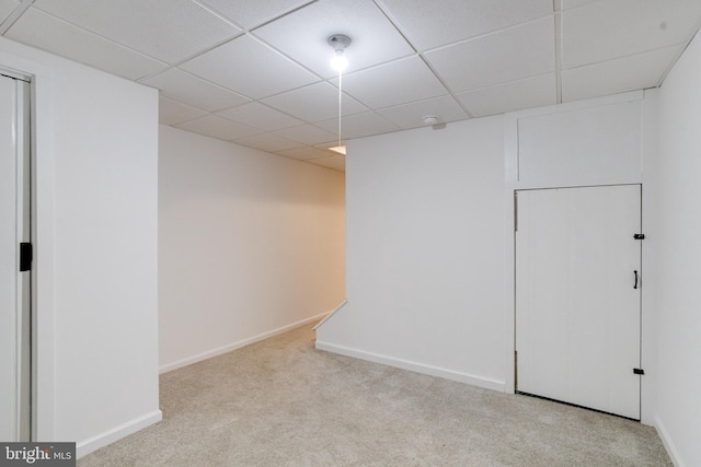 carpeted spare room with a paneled ceiling