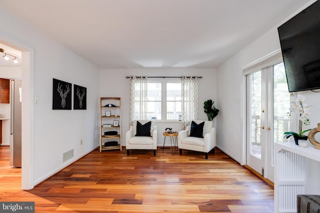 sitting room featuring french doors and light hardwood / wood-style flooring