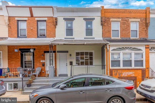 townhome / multi-family property featuring covered porch