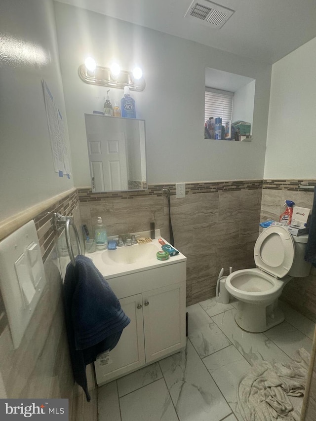 bathroom featuring tile walls, large vanity, backsplash, tile flooring, and toilet