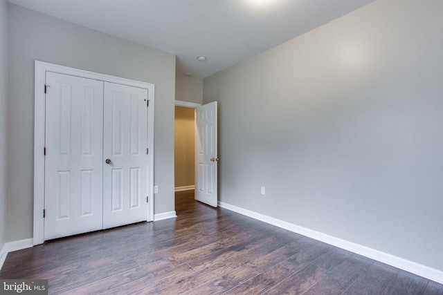 unfurnished bedroom featuring a closet and dark hardwood / wood-style floors