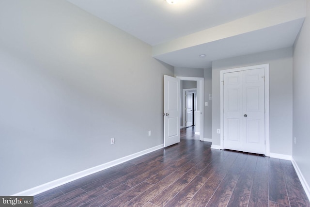 spare room with dark wood-type flooring