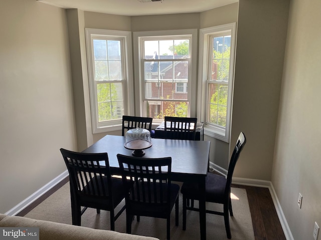 dining area with plenty of natural light and hardwood / wood-style flooring