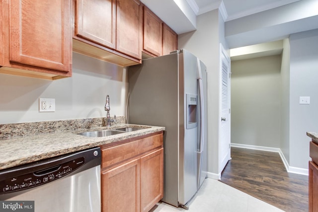 kitchen featuring light stone countertops, sink, crown molding, and stainless steel appliances