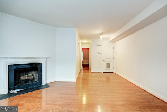 unfurnished living room featuring crown molding and light hardwood / wood-style flooring