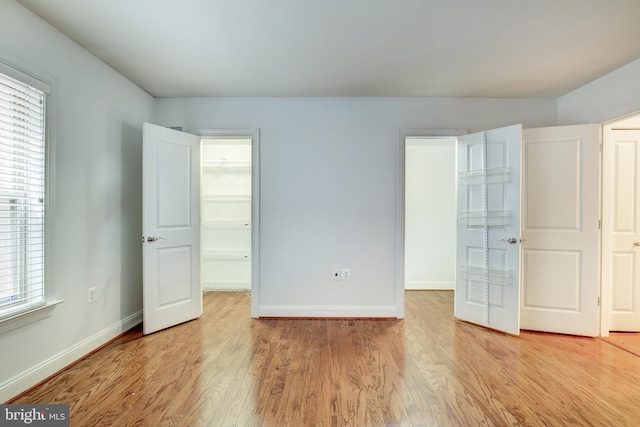 unfurnished bedroom featuring light hardwood / wood-style floors and multiple windows