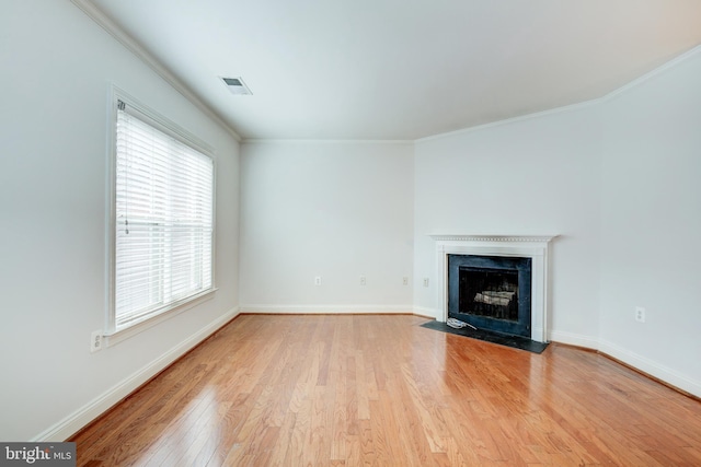 unfurnished living room with ornamental molding and light hardwood / wood-style flooring