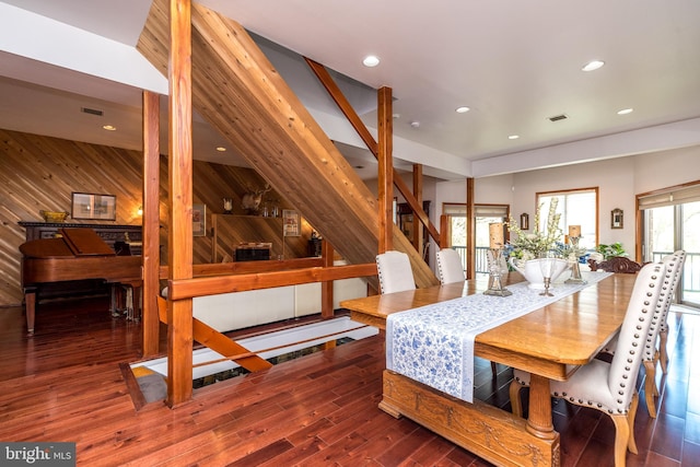 dining room with wooden walls and dark hardwood / wood-style flooring