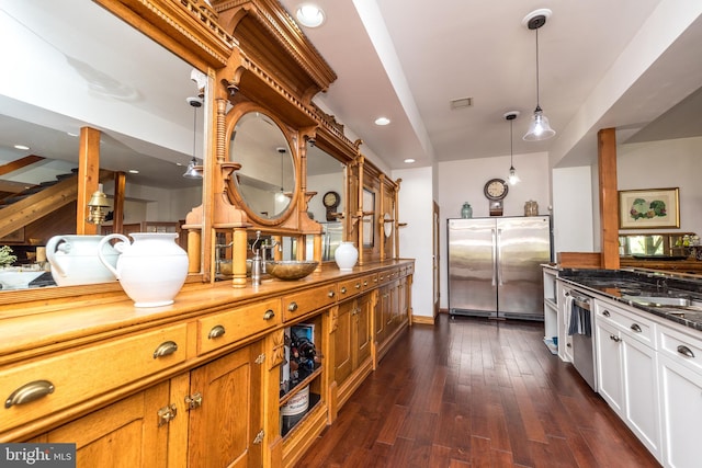 kitchen featuring dark hardwood / wood-style floors, stainless steel appliances, hanging light fixtures, sink, and white cabinetry