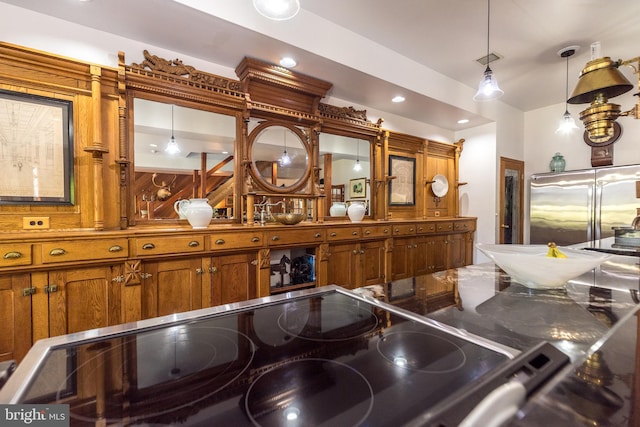 interior space featuring hanging light fixtures, stove, and high end fridge