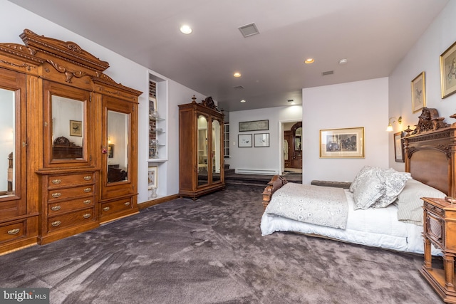 bedroom with dark carpet and a baseboard heating unit