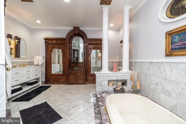 bathroom with tile floors, decorative columns, vanity, and a bath to relax in