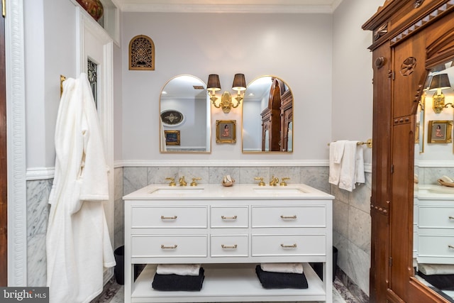 bathroom with tile walls, ornamental molding, and double sink vanity