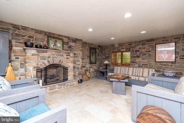 tiled living room with a stone fireplace