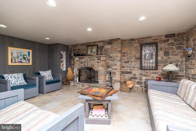 tiled living room with a fireplace and wooden walls