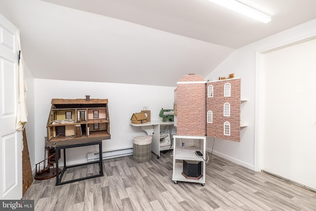 misc room featuring wood-type flooring, a baseboard radiator, and vaulted ceiling