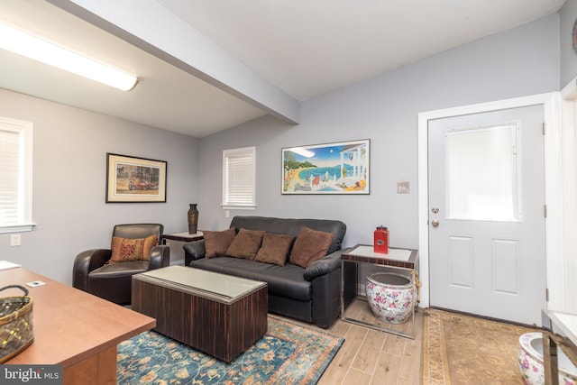 living room featuring light hardwood / wood-style floors and beam ceiling