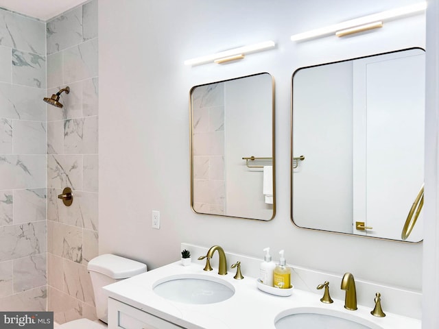 bathroom with vanity, a tile shower, and toilet