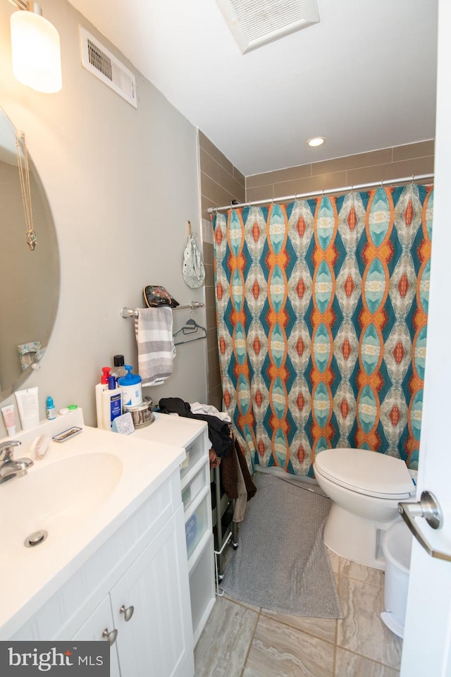 bathroom featuring toilet, tile floors, and large vanity