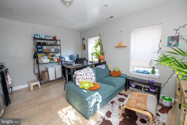 living room with plenty of natural light and light hardwood / wood-style flooring