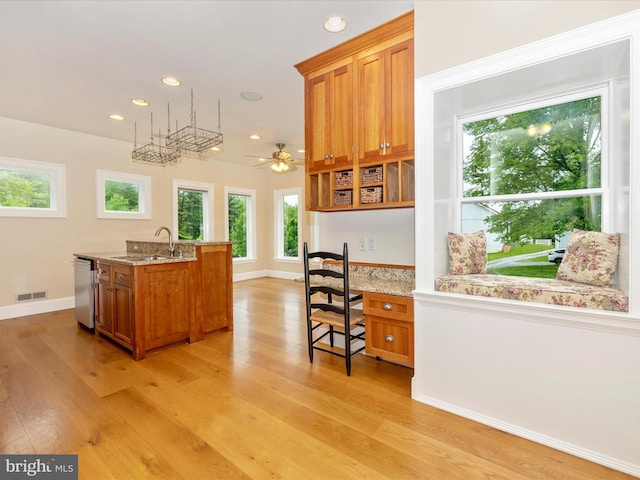 kitchen with ceiling fan, sink, light hardwood / wood-style floors, and a healthy amount of sunlight