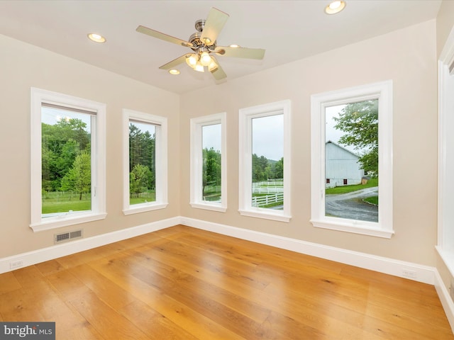 empty room with ceiling fan and hardwood / wood-style flooring