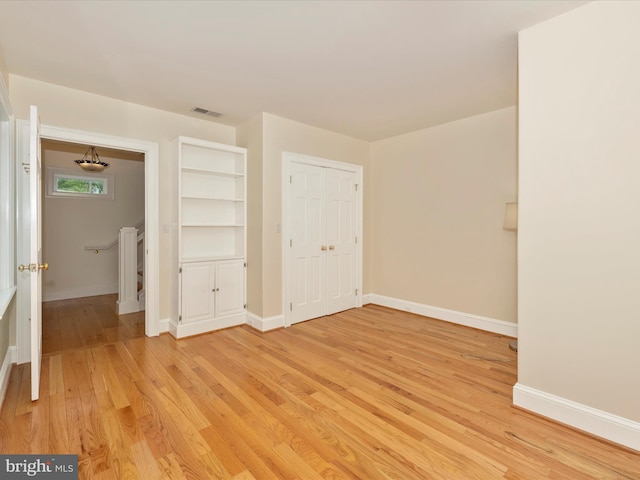 unfurnished bedroom with a closet and light hardwood / wood-style flooring