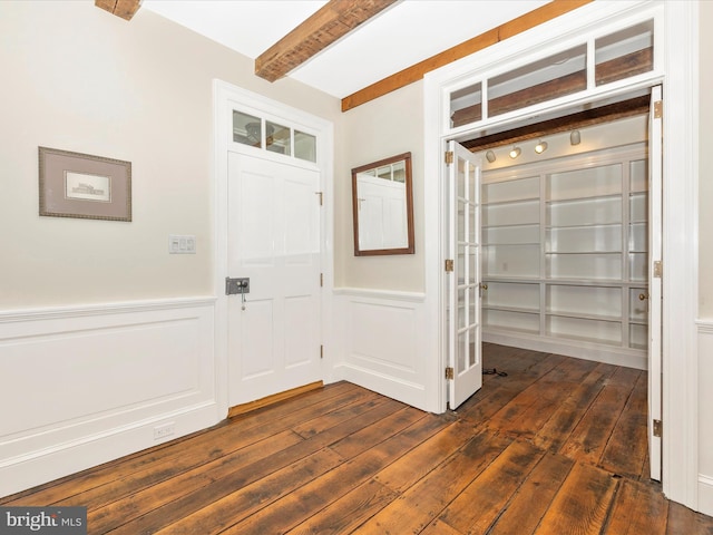 foyer featuring beamed ceiling and dark wood-type flooring